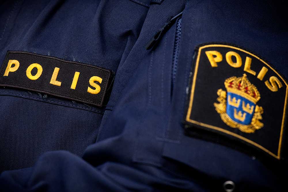 Närbild på en mörkblå svensk polisuniform