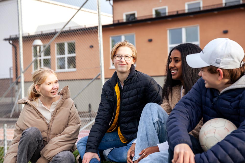 Ungdomar som sitter ute på rastplatsen på skolan